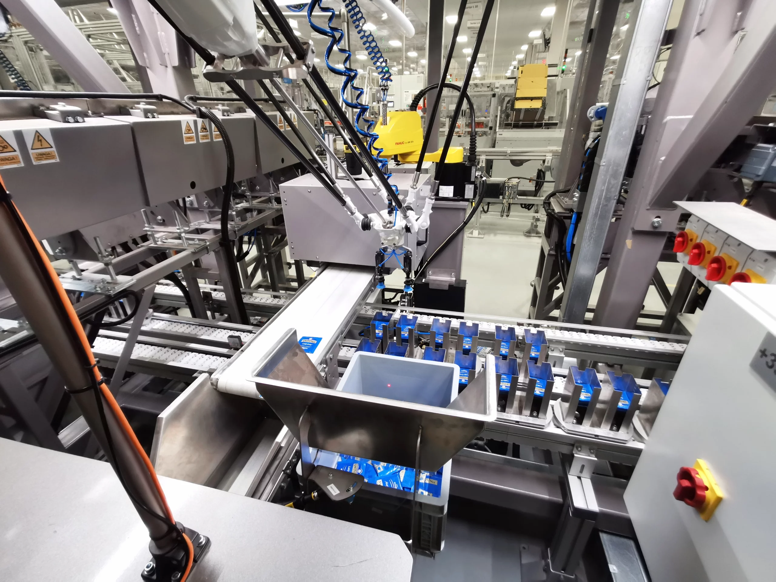 Robotyczne gniazdo w linii miksowania saszetek z herbatą w opakowaniach detalicznych – automatyzacja procesu pakowania.