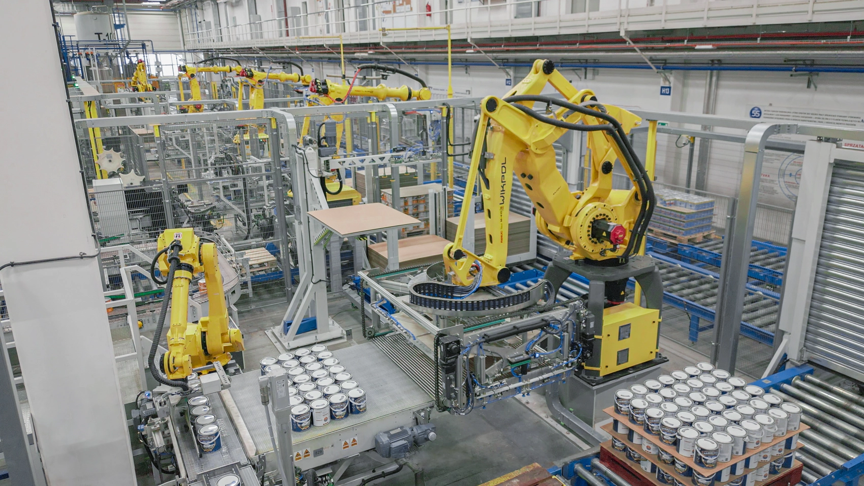 Roboty kompletujące i paletyzujące puszki z farbą oraz układające przekładki – system paletyzacji wdrożony przez Wikpol